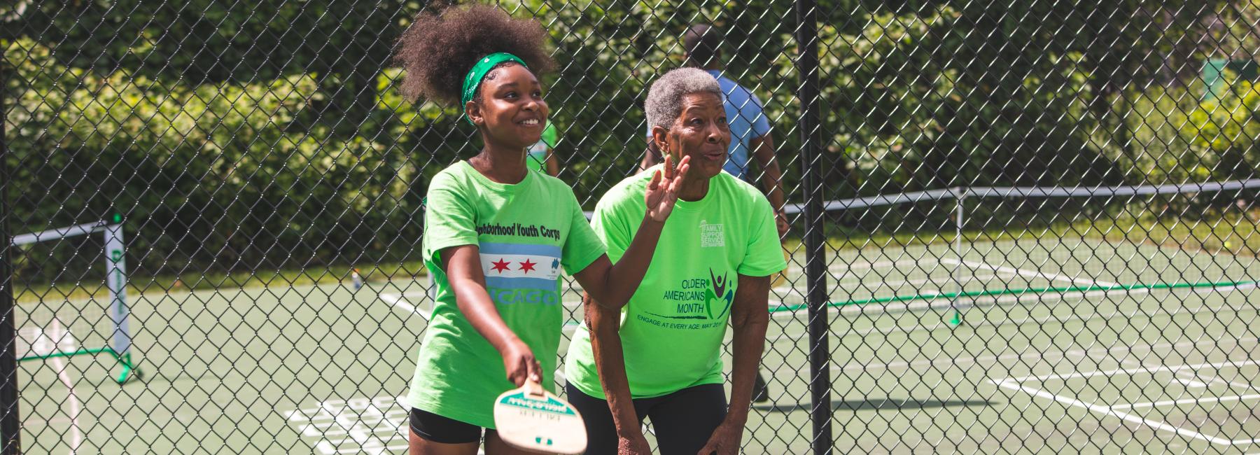 A CHA senior resident and youth enjoy a game of pickleball together 