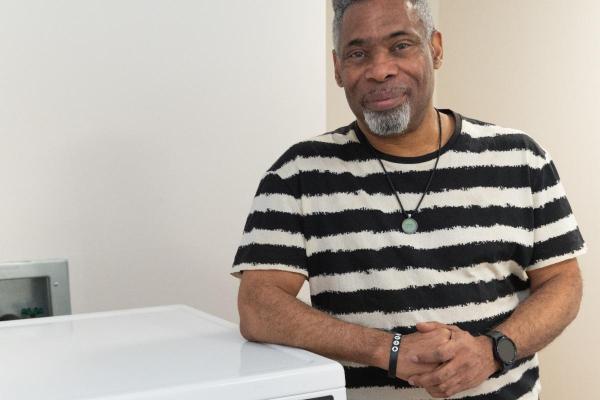 CHA Senior Resident in front of his building's new commercial grade washers