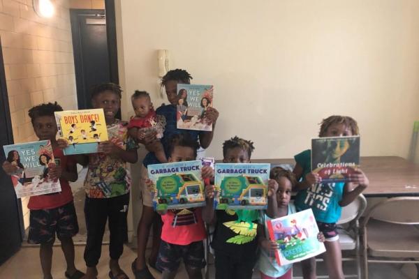 A group of kids holding up books.